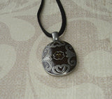 brown leather necklace with metallic pendant